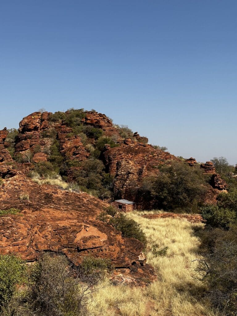 Rote Felsformationen und Buschlandschaft im Revier der Jagdoase