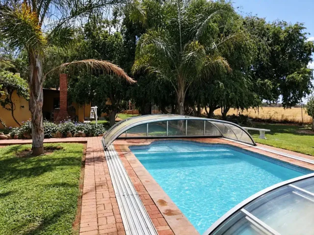 Farm Capbon – Pool im Garten mit Palmen